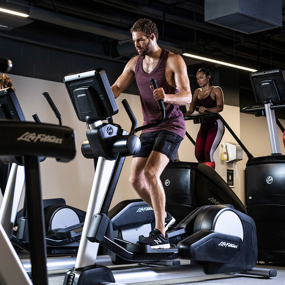 Male exercising on Life Fitness Elliptical in gym