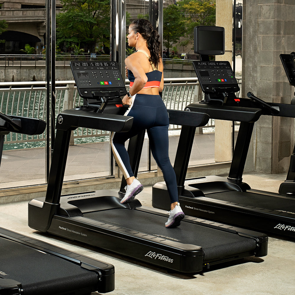 Female running in club on Club Series+ Treadmill, Black Onyx Base