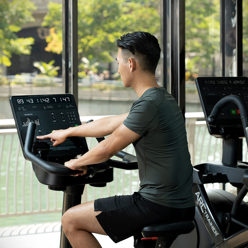 Exerciser interacting with SL console on Life Fitness upright bike