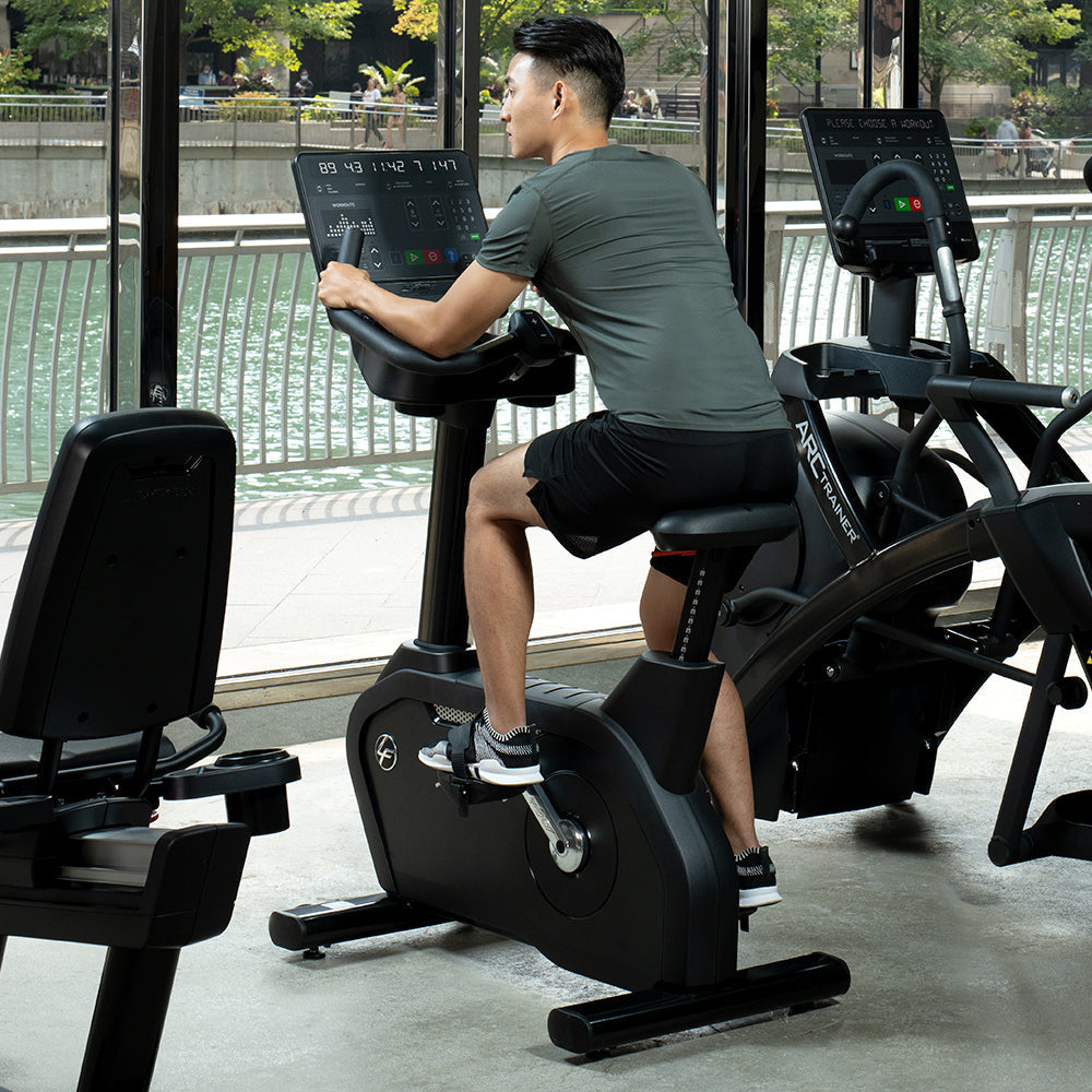 Man pedaling on Life Fitness Upright Bike in gym, SL console