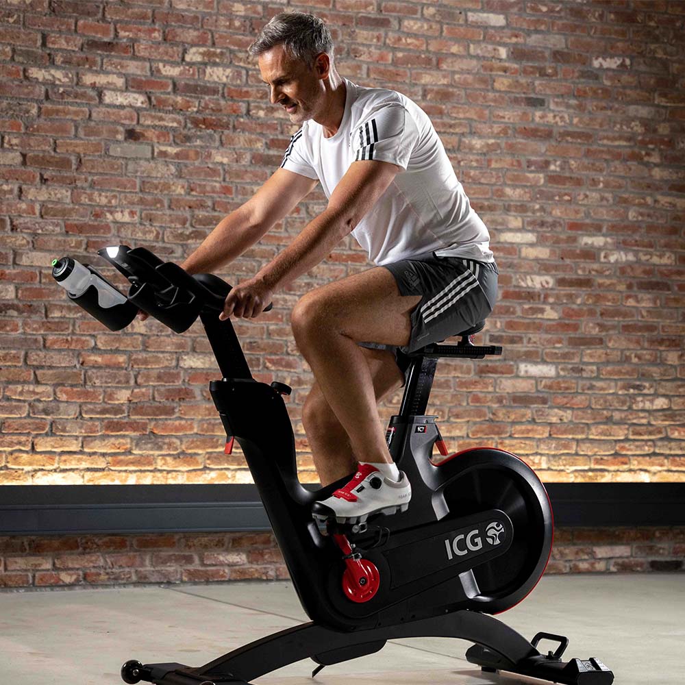 Man at home riding IC7 bike, side profile