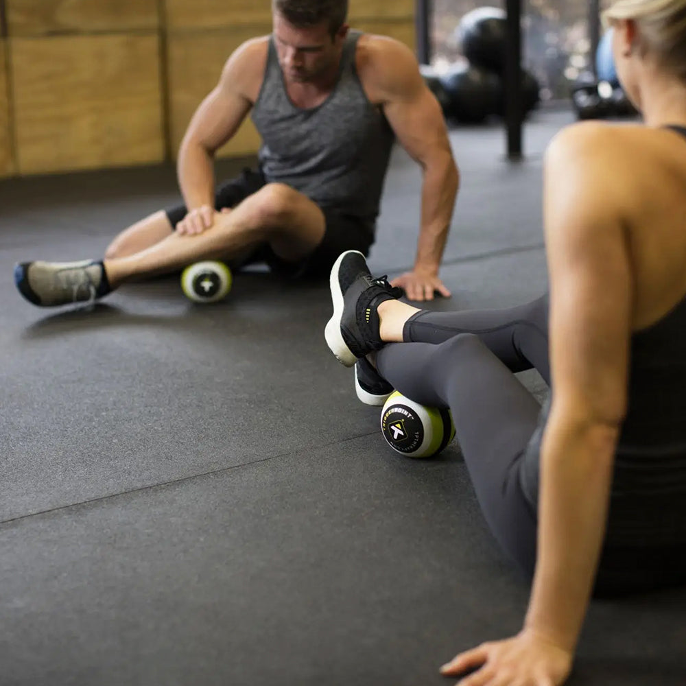 Exercisers using MB5 Massage Ball, rolling out calves